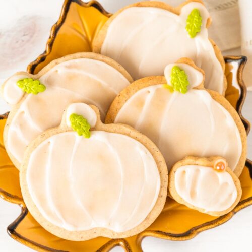 Small batch of decorated pumpkin spice sugar cookies arranged on a fall plate.