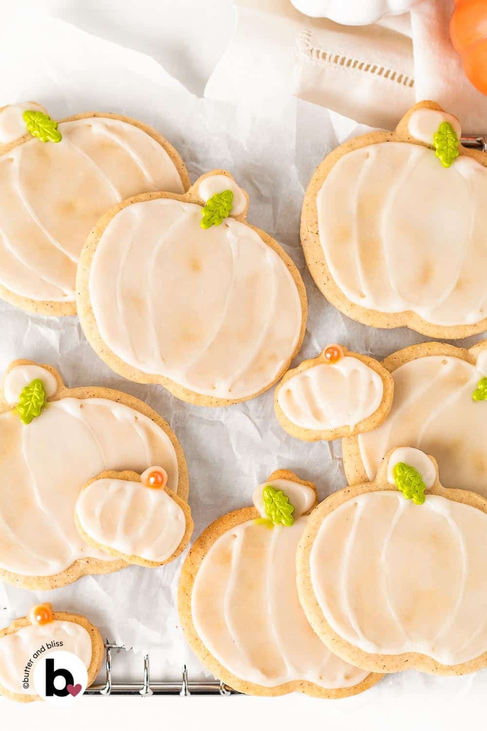 Decorated pumpkin spice sugar cookies on a wire cooling rack.