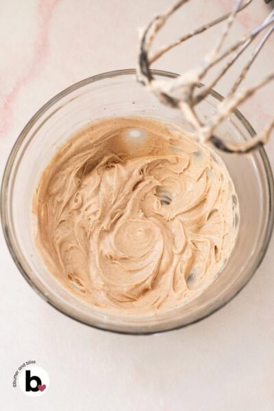 Smooth cream cheese mixed with maple syrup in a mixing bowl.
