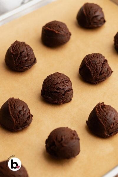 Dough balls of small batch chocolate andes mint cookies on a baking sheet.