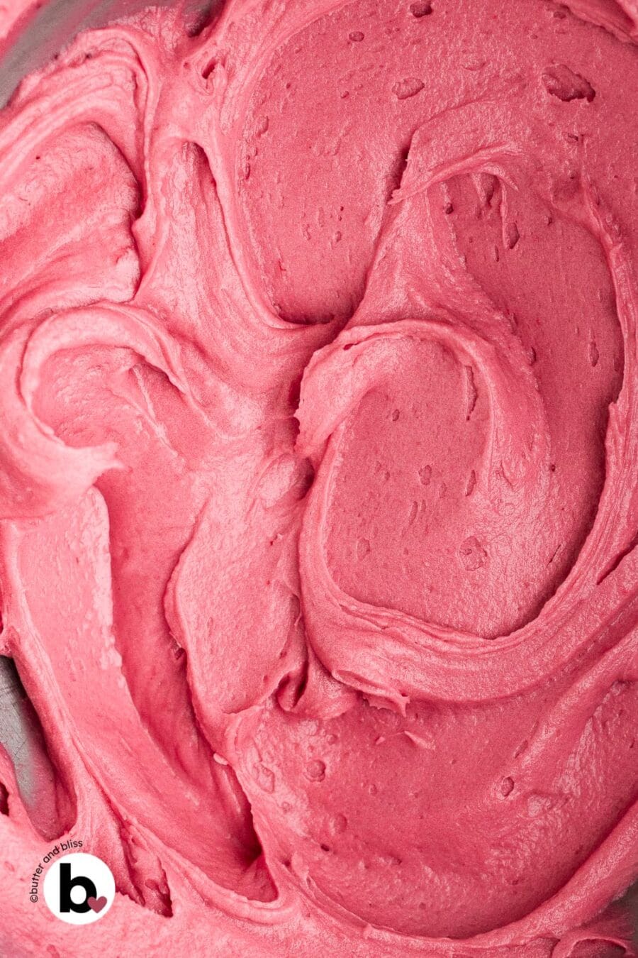 Creamy swirls of cranberry buttercream frosting in a bowl.