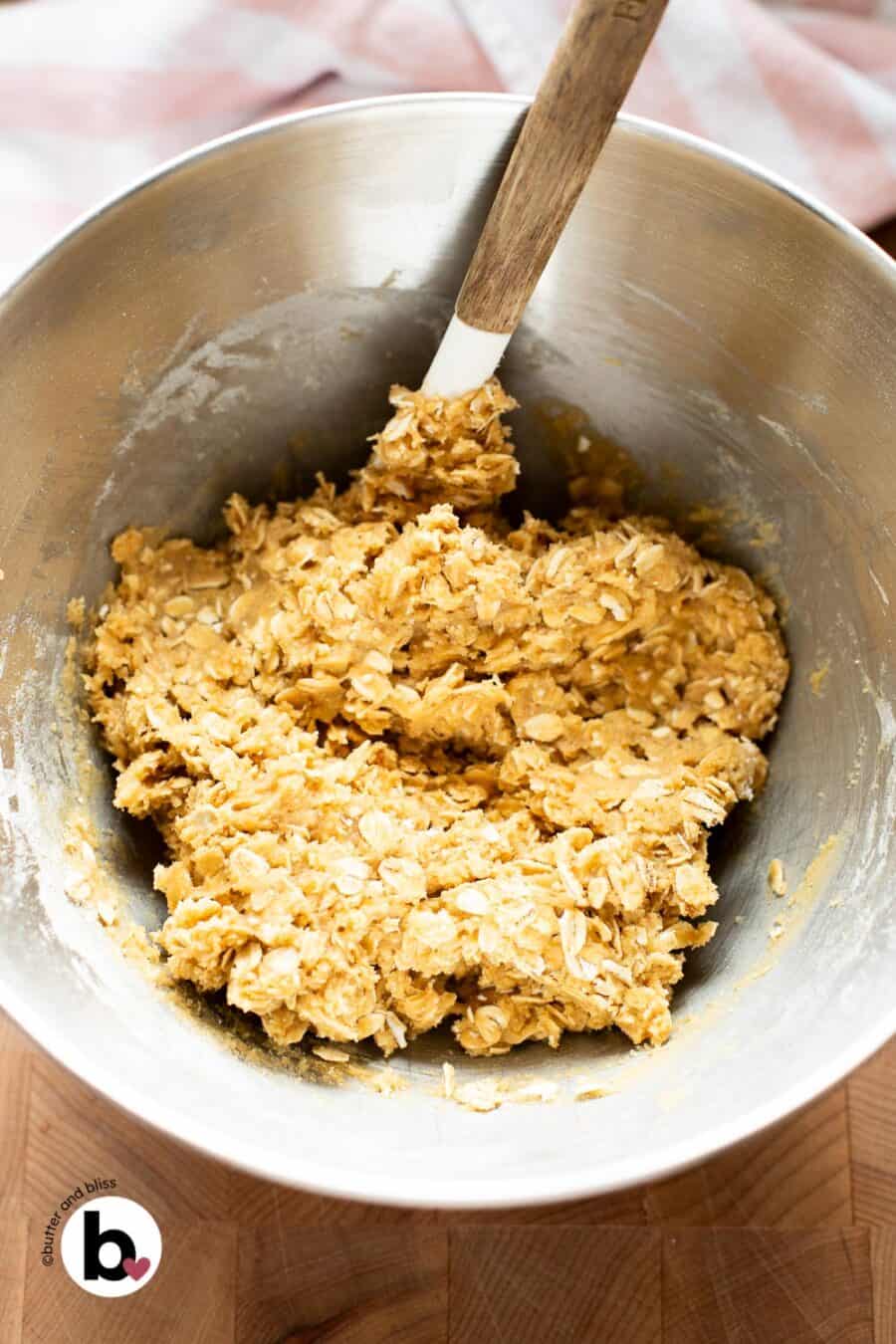 Thick oatmeal cookie dough in a mixing bowl.
