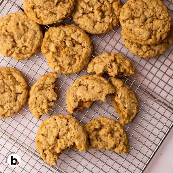 Several oatmeal cookies with a bite on a wire cooling rack.
