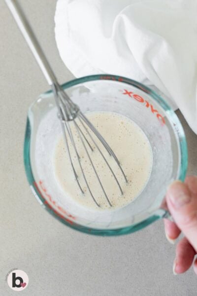 Wet cupake ingredients being mixed in a liquid measuring cup.