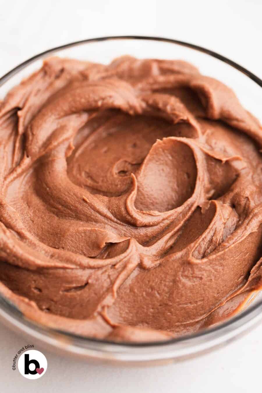 Peaks of fluffy whipped chocolate ganache in a mixing bowl.