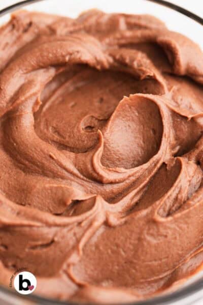 Soft swirls of chocolate whipped ganache in a mixing bowl.