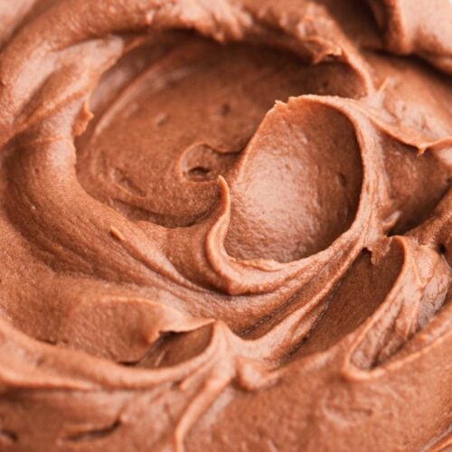 Soft swirls of chocolate whipped ganache in a mixing bowl.