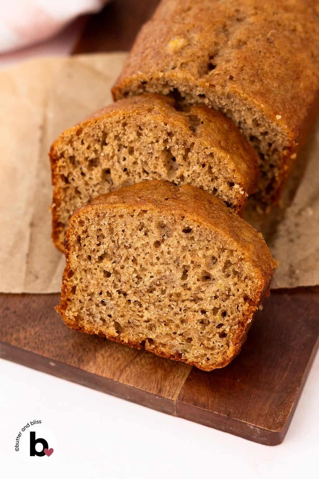 Cut slices of small banana bread on a cutting board revealing soft and moist crumb.