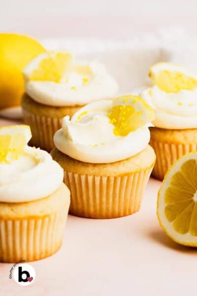 A small batch of lemon cupcakes with bright lemon frosting arranged on a table.