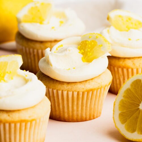 A small batch of lemon cupcakes with bright lemon frosting arranged on a table.