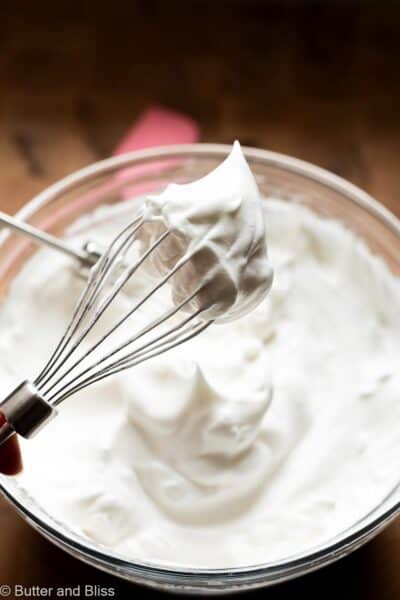Egg whites beaten to soft peaks in on a whisk.