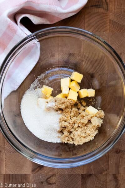Sugars and butter cubes in a mixing bowl, ready to be combined.