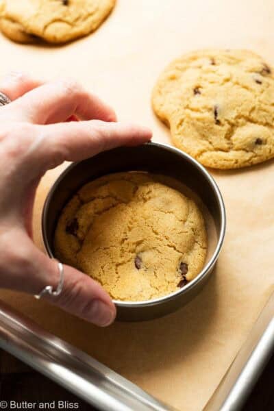 Hand shaping a perfectly round cookie inside a round cookie cutter.