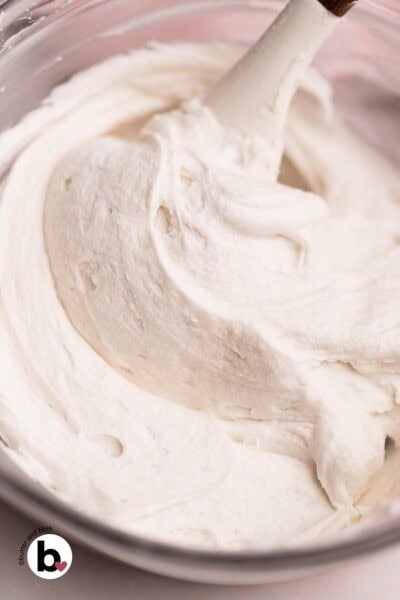 Thick and creamy vanilla frosting made without butter or cream cheese in a mixing bowl.