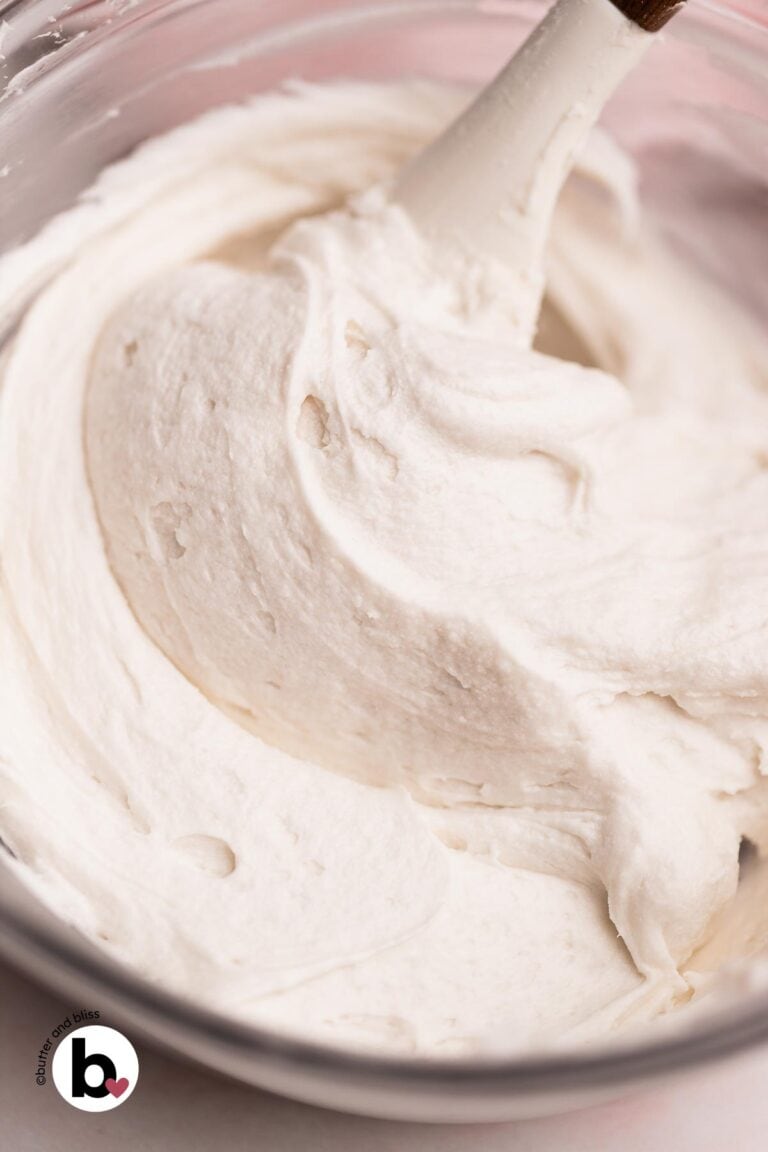 Thick and creamy vanilla frosting made without butter or cream cheese in a mixing bowl.