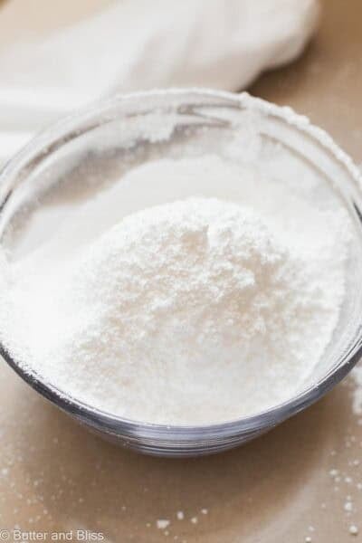 Fluffy powdered sugar that has been sifted into a mixing bowl.