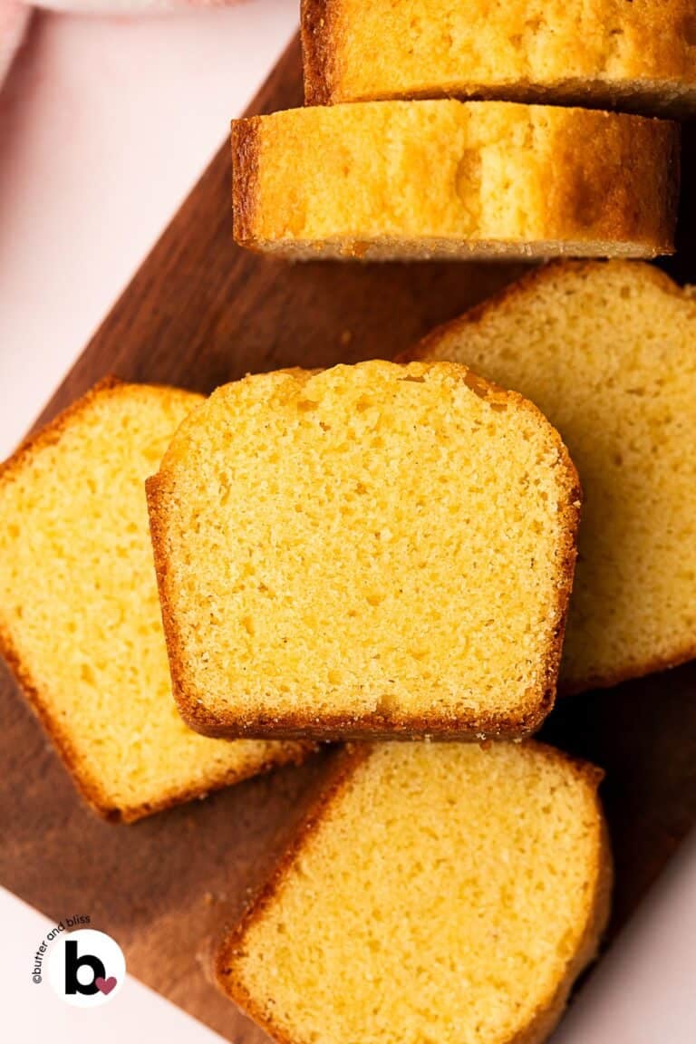 A small pound cake cut into slices and arranged on a cutting board.