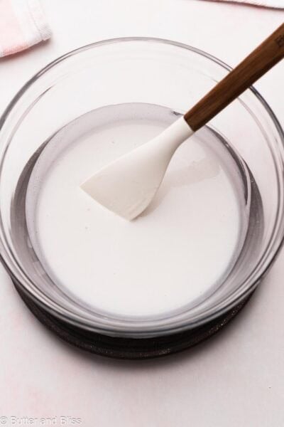 Melted coconut cream and oil in a mixing bowl to make frosting.