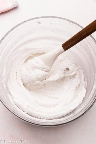 Last process of making vanilla butter free frosting in a mixing bowl.