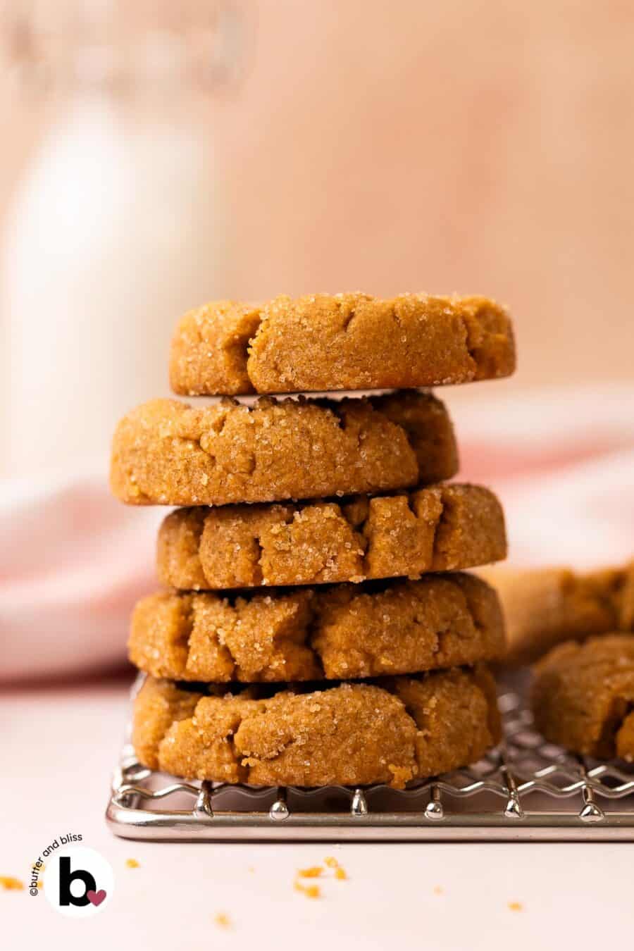 A small stack of thick and chewy peanut butter cookies on a wire rack.