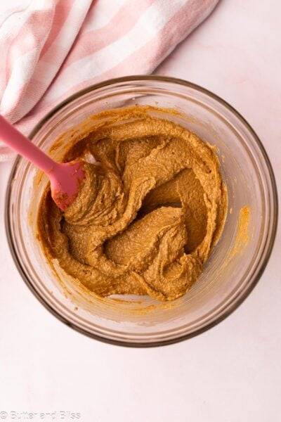 Smooth peanut butter ocokie wet ingredients mixed in a bowl.