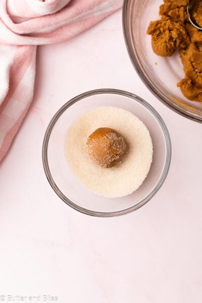 Peanut butter cookie dough ball rolled in sugar in a small bowl.