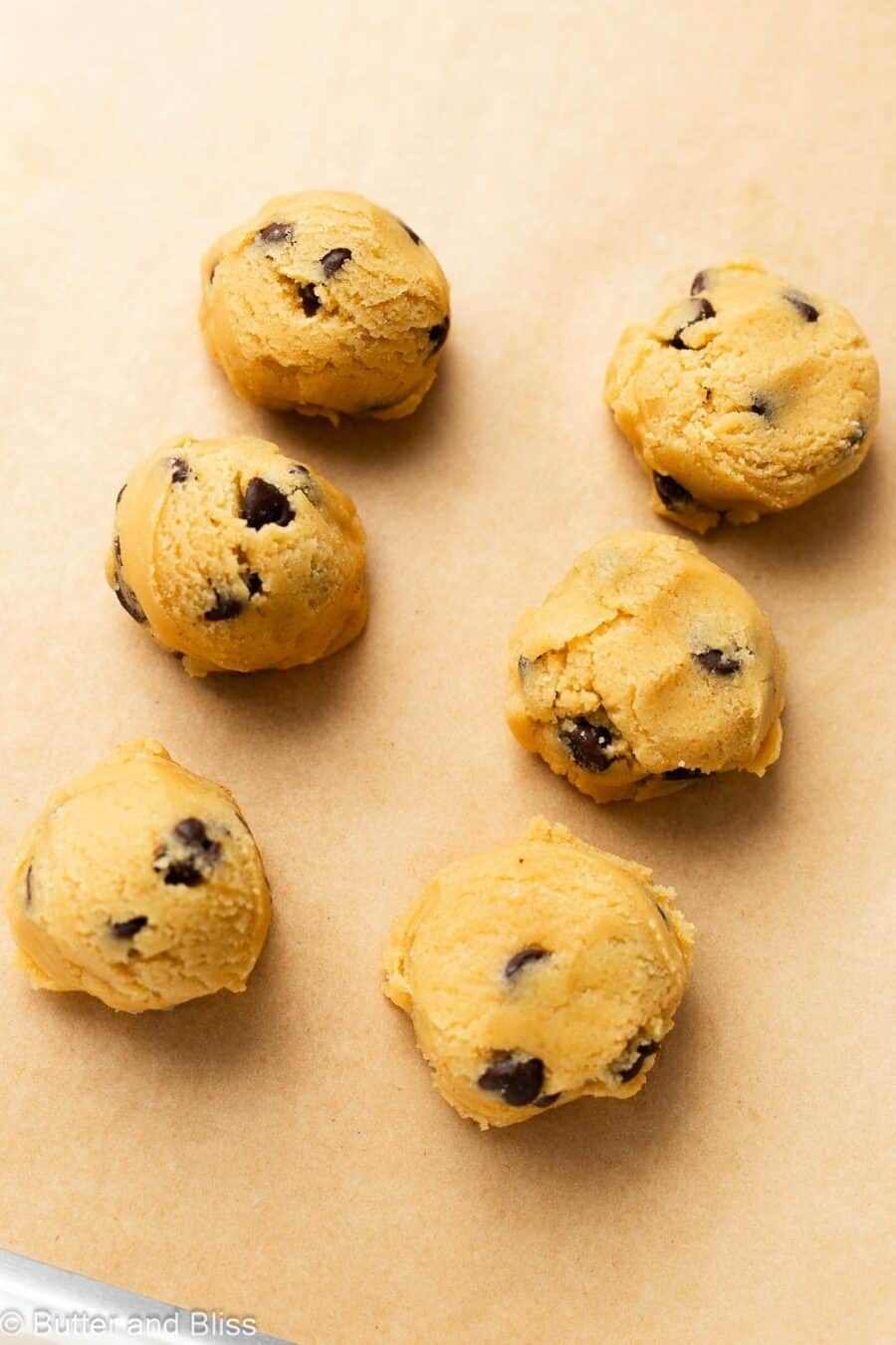 Chocolate chip cookie dough balls on a baking sheet.