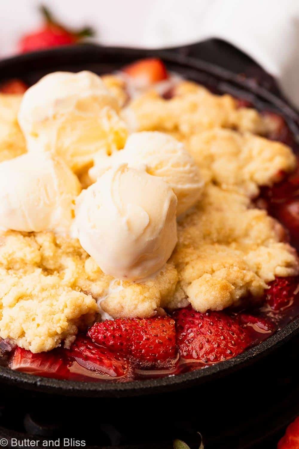 Juicy strawberry cobbler with biscuit top in a mini skillet.