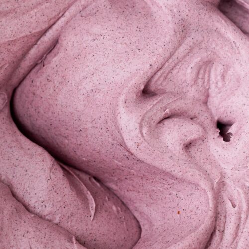 Fluffy blueberry dairy free whipped cream in a mixing bowl.