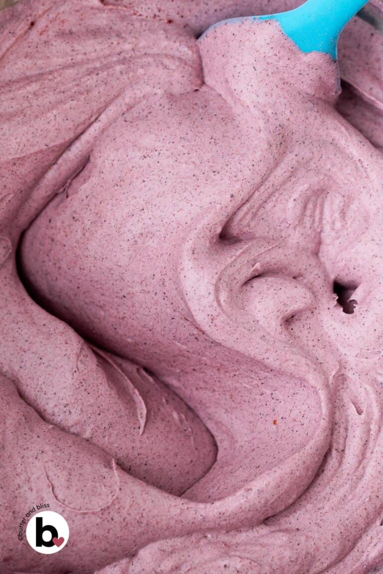 Fluffy blueberry dairy free whipped cream in a mixing bowl.