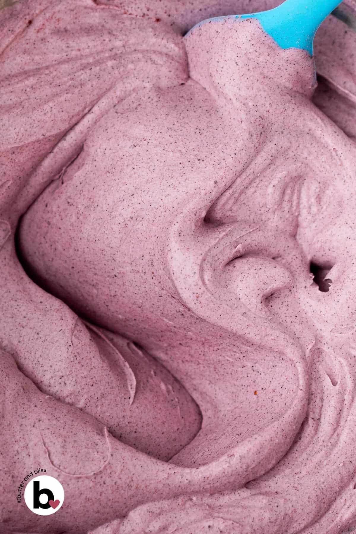 Fluffy blueberry dairy free whipped cream in a mixing bowl.