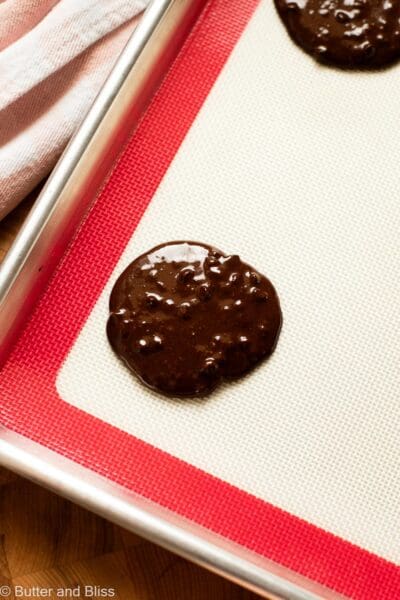 Dollop of flourless chocolate cookie batter on a baking mat.