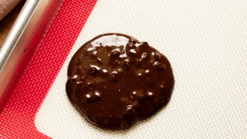 Dollop of flourless chocolate cookie batter on a baking mat.