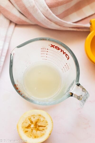 Fresh lemon juiced into a measuring cup.