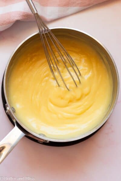 Thick pastry cream being cooked in a saucepan.