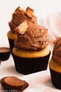 Peanut butter cupcake with chocolate frosting on a table.