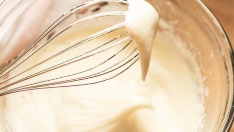 Fluffy egg white whipped to soft peaks in a mixing bowl.