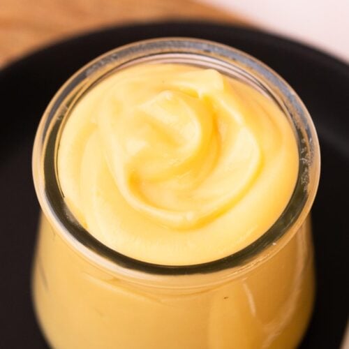 Silky vanilla pastry cream swirled into a small glass jar.