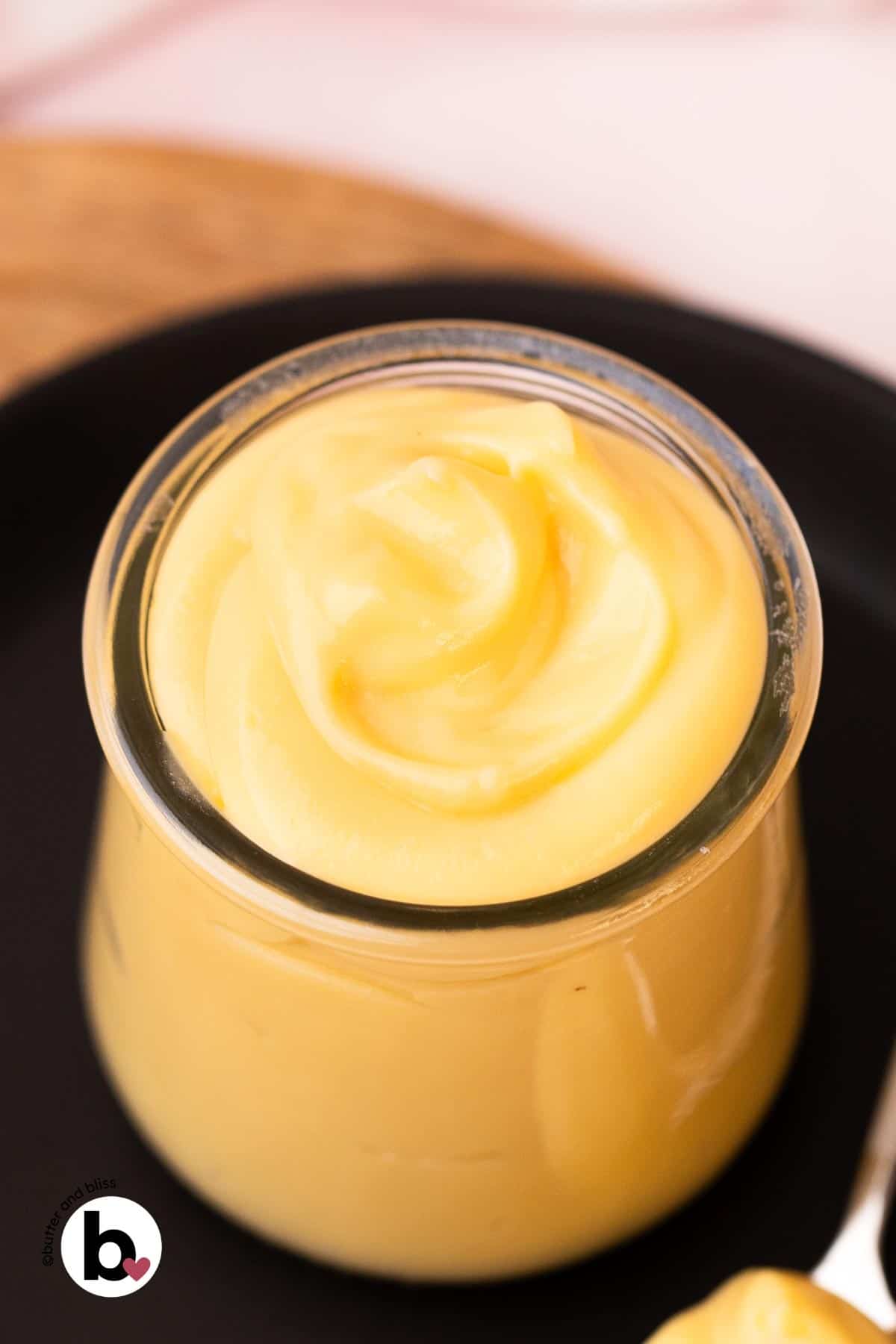 Silky vanilla pastry cream swirled into a small glass jar.
