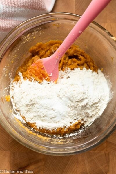 Dry ingredients added to wet cookie ingredients in a mixing bowl.