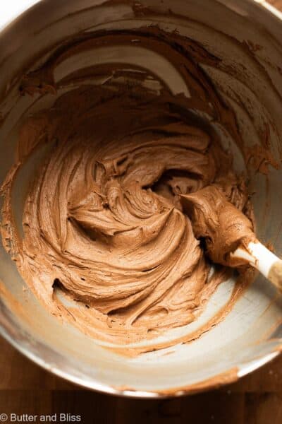 Chocolate buttercream with light whipped texture in a mixing bowl.