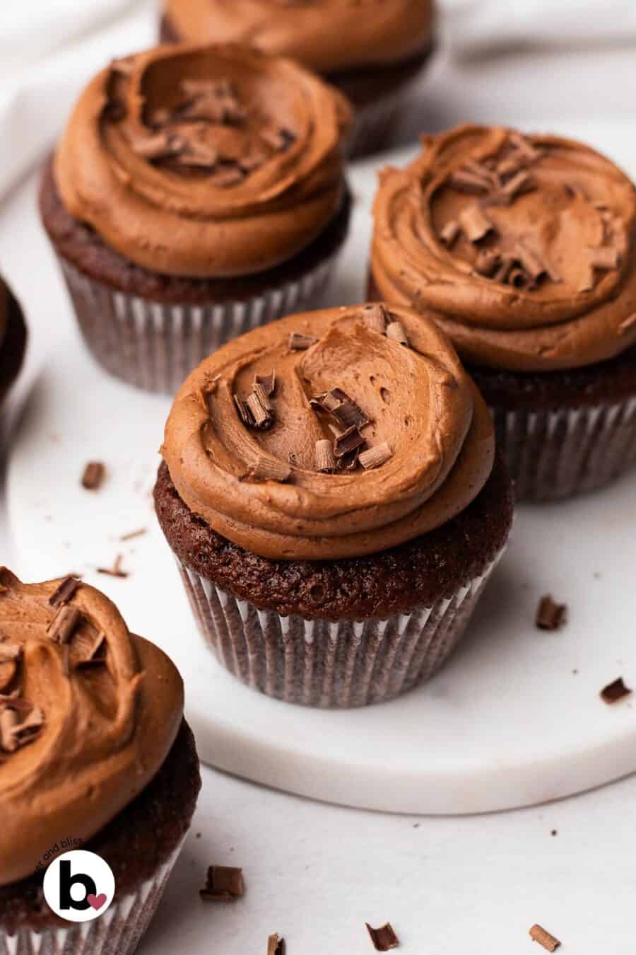 Frosted small batch of chocolate cupcakes arranged on a table.
