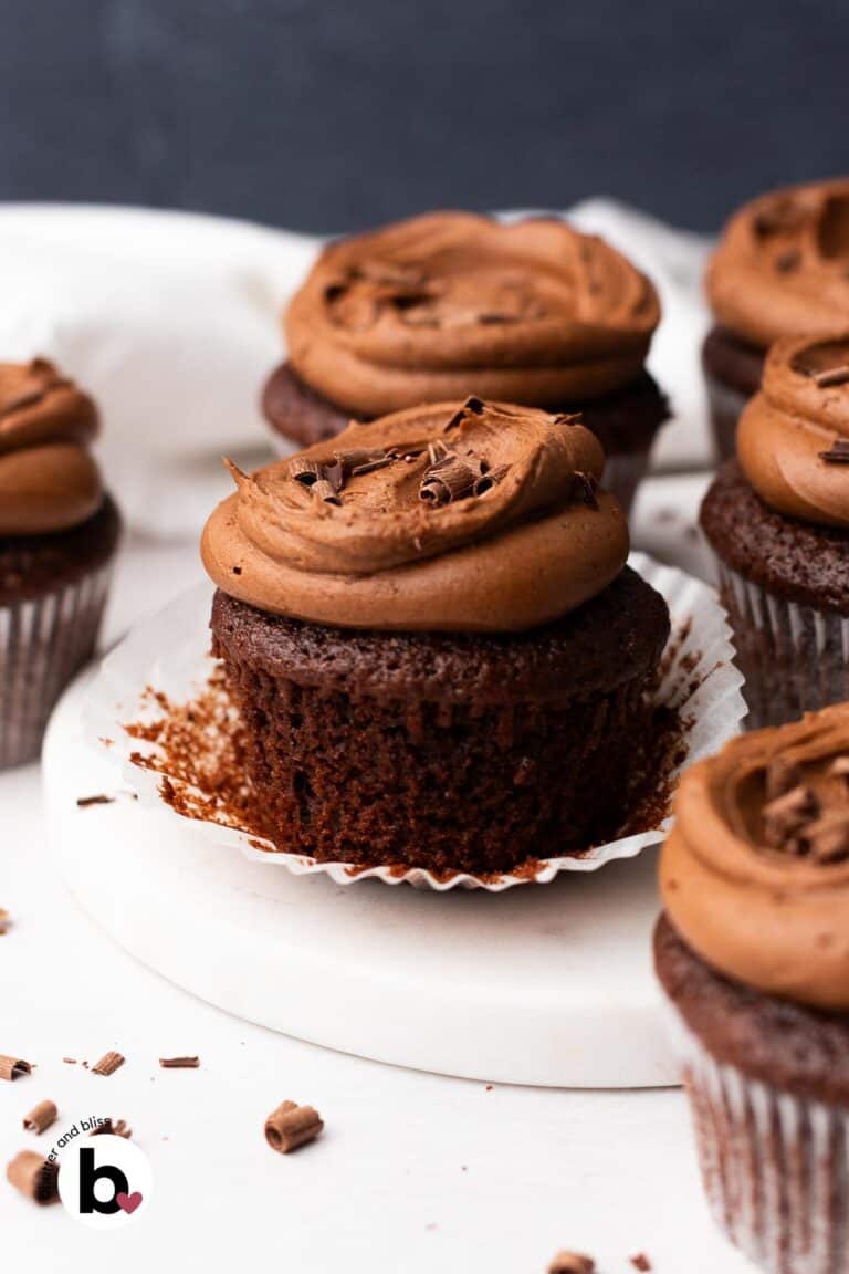 Cupcake liner peeled back on a moist chocolate frosted cupcake.