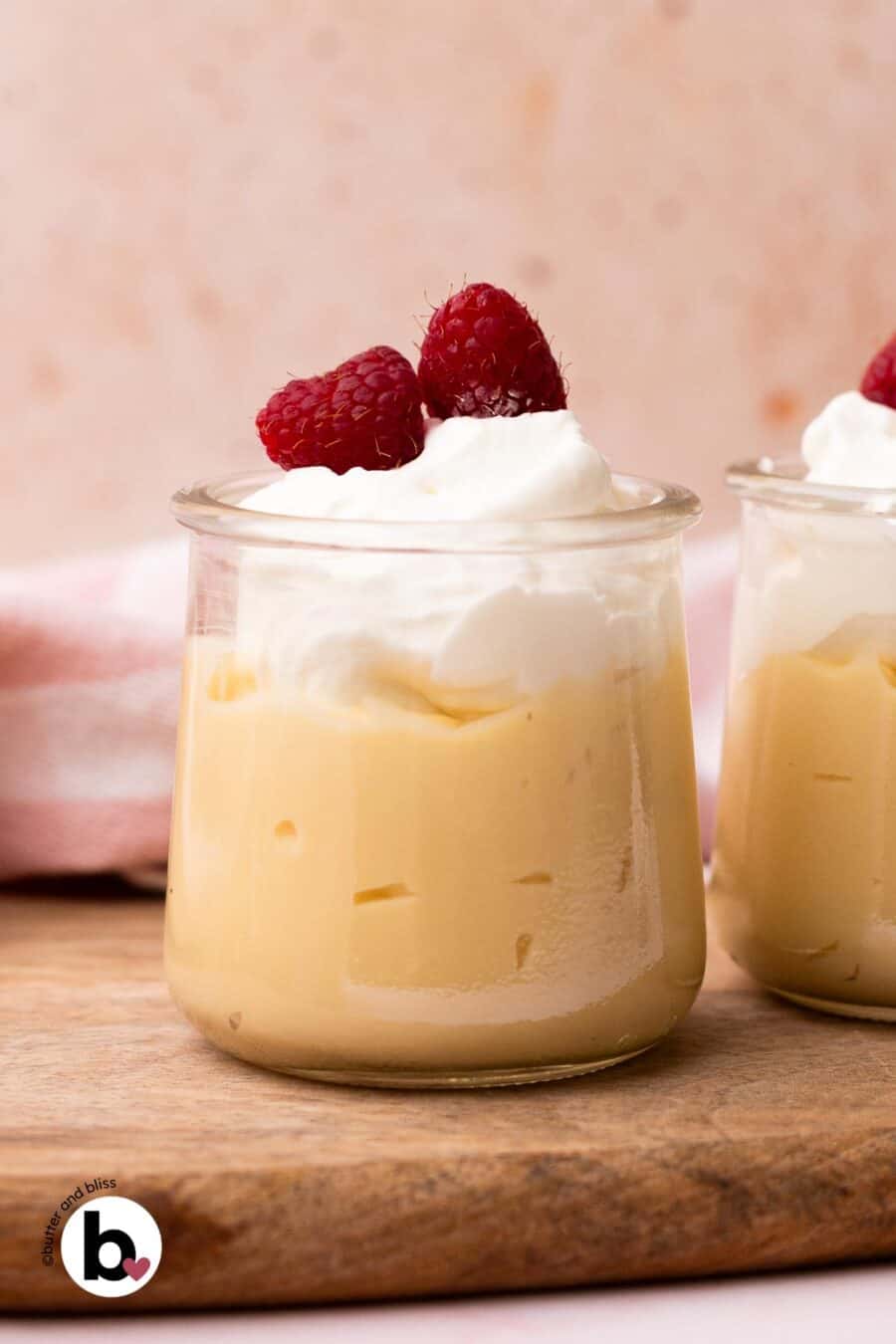 Vanilla pudding in a small glass topped with whipped cream and fruit.