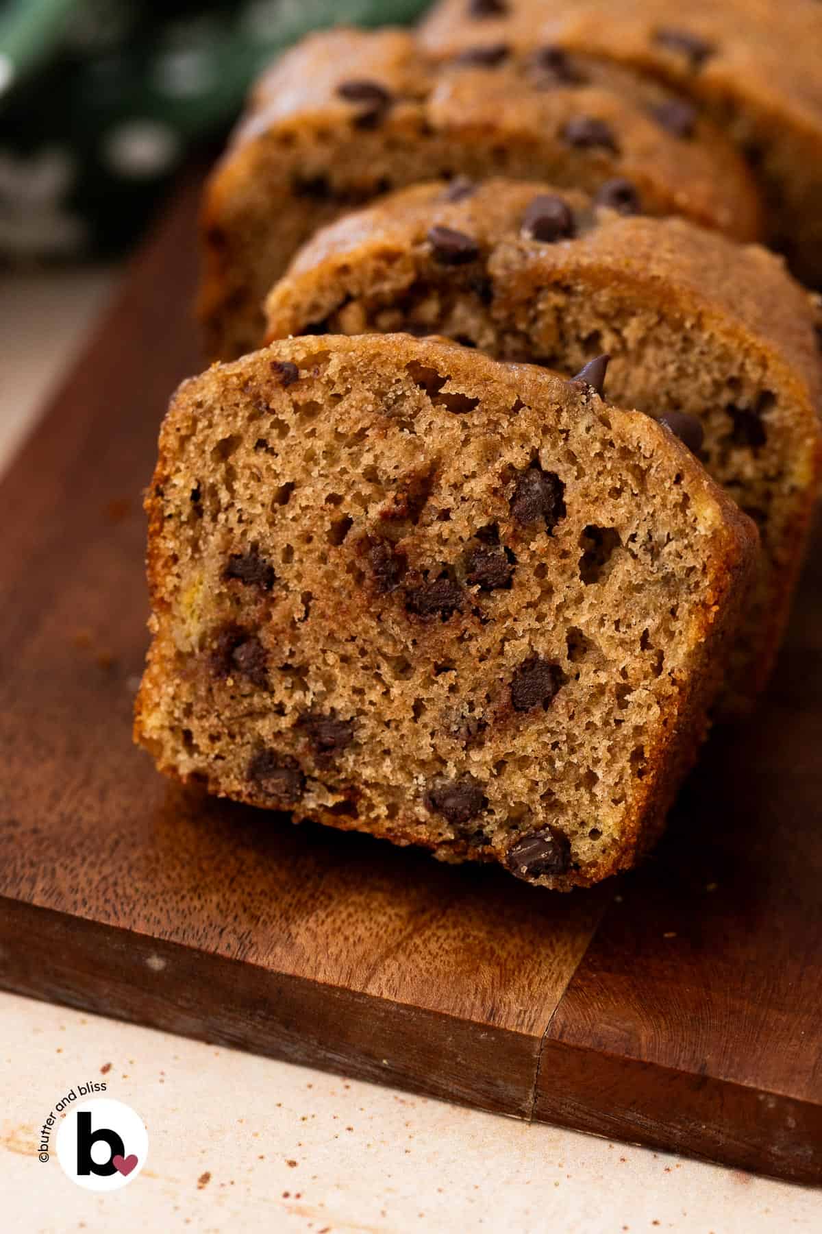 Slice of banana bread on a cutting board revealing chocolate chips throughout.