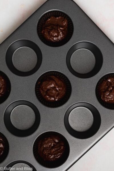 Eggless chocolate cupcake batter in a cupcake pan.