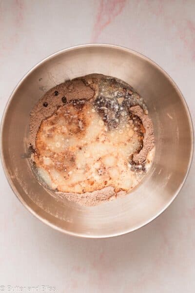 Chocolate eggless cupcake batter being mixed in a mixing bowl.