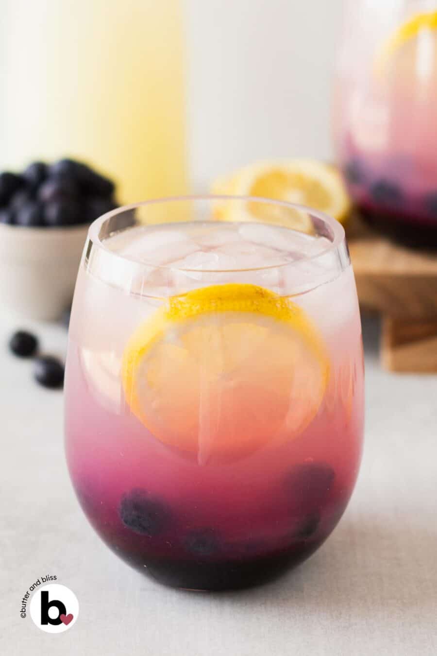 Homemade blueberry lemonade in a glass with lemon slice and blueberries.