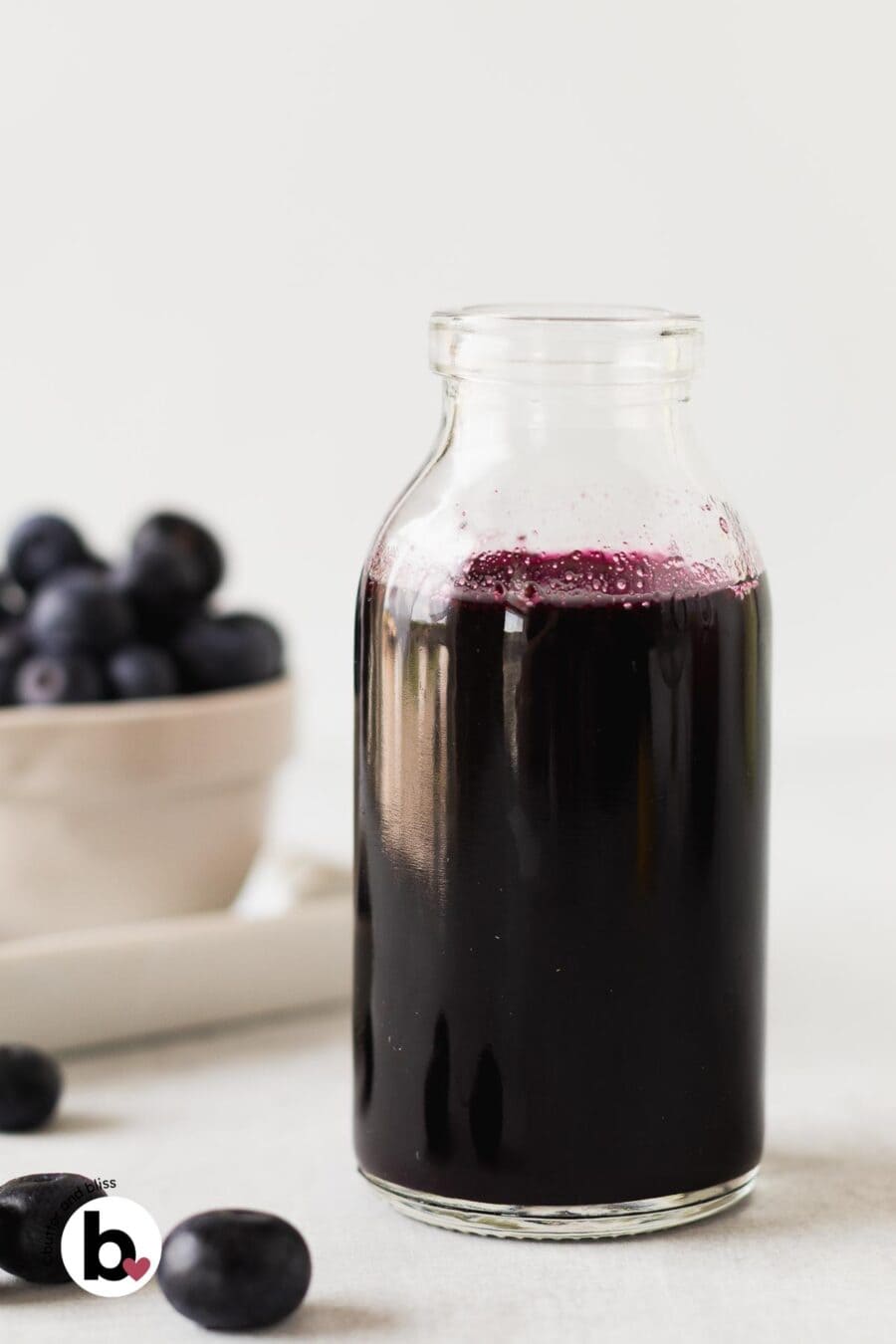 Homemade blueberry simple syrup in a small jar.