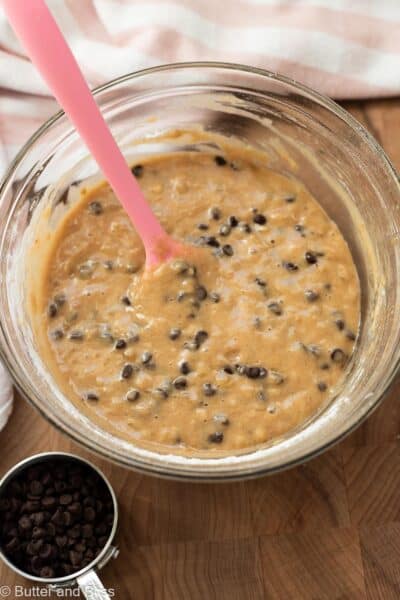 Chocolate chips folded into banana bread batter in a mixing bowl.